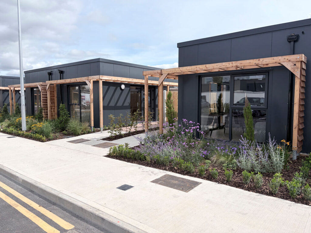 Exterior of the Estuary Way building with planting and a timber pergola