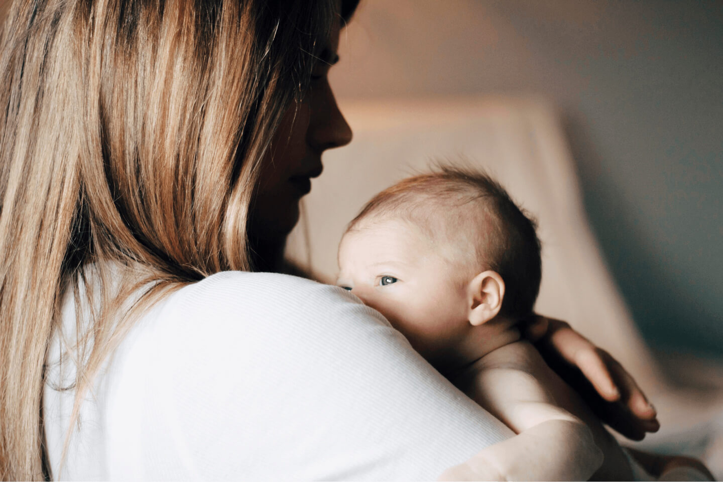 A mother holding her baby against her shoulder