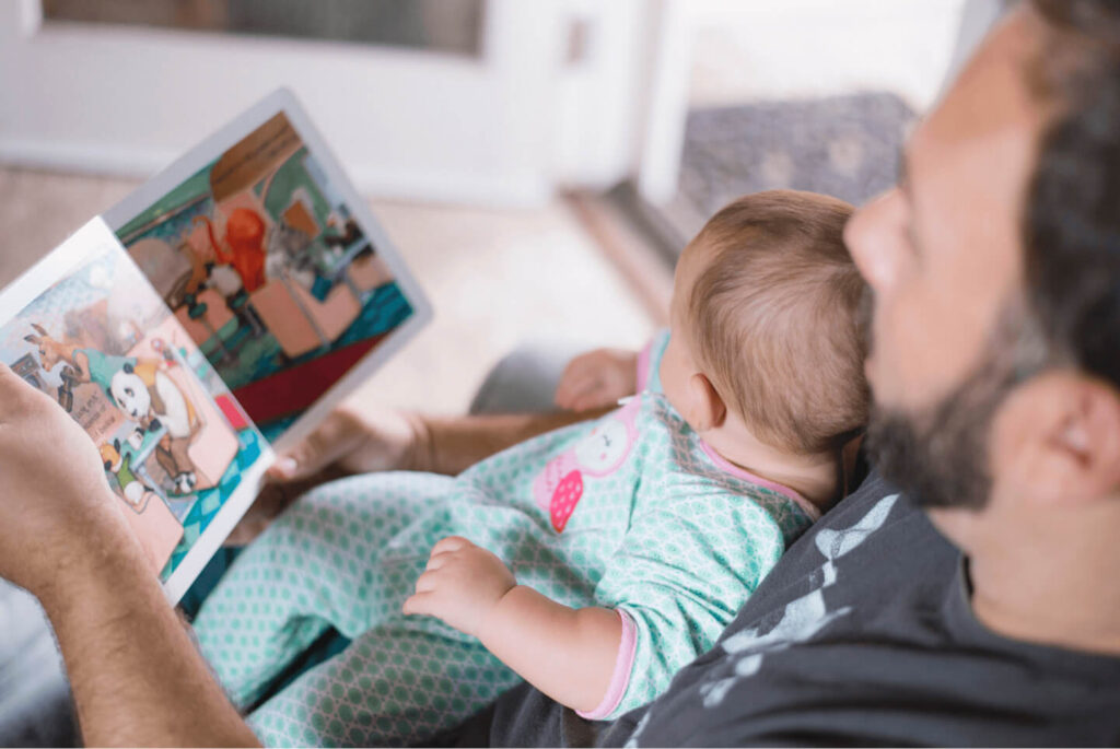 A father reading a picture book with his baby
