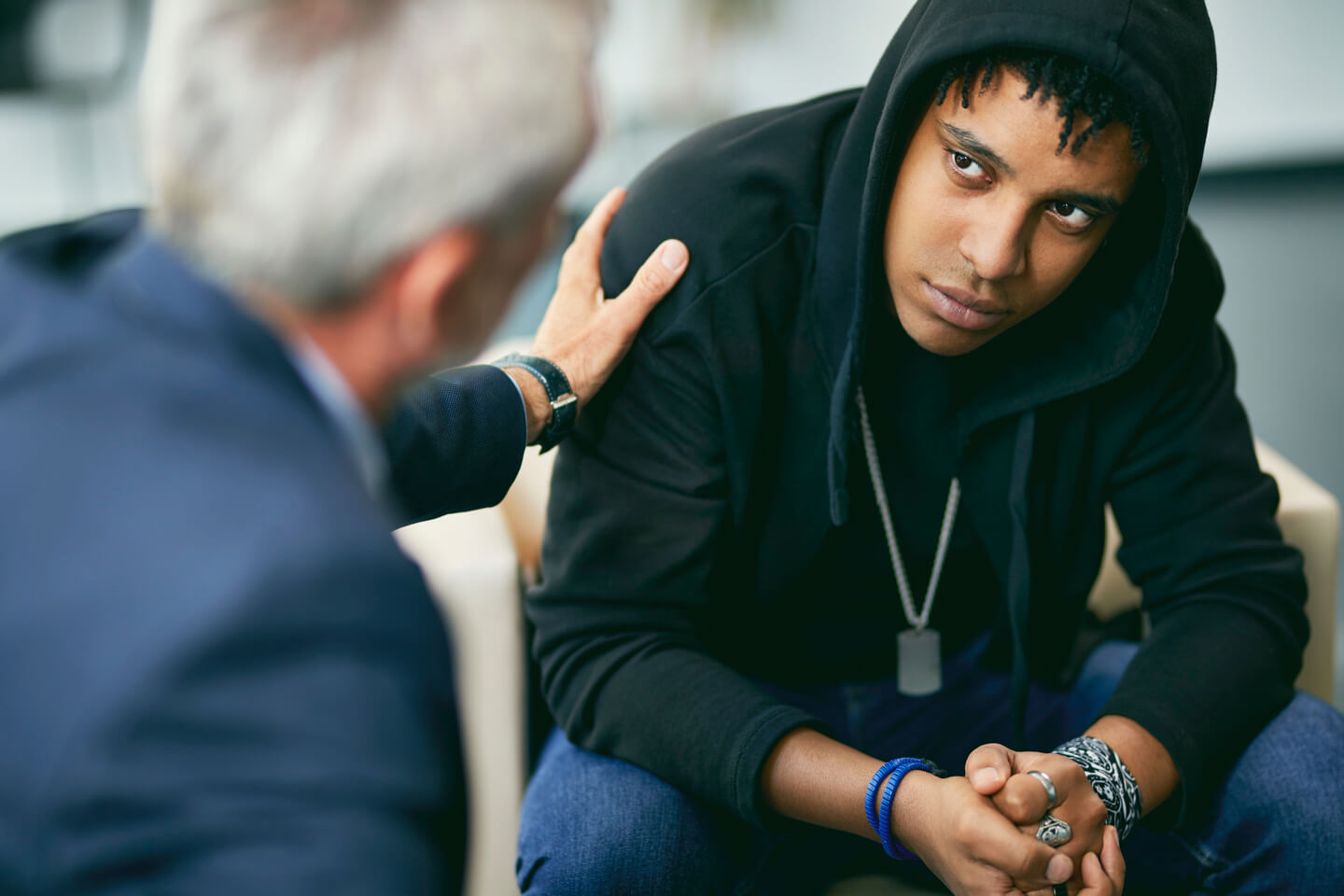 A professional in a suit talking with a young man